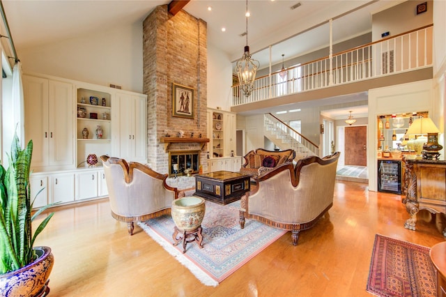 16123 Chasemore Dr, Spring, TX 77379 - living area featuring high vaulted ceiling, wine cooler, light wood-style flooring, a fireplace, and stairway