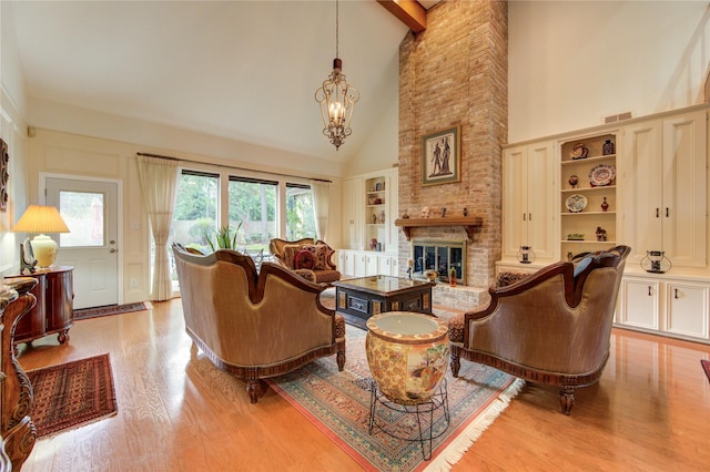16123 Chasemore Dr, Spring, TX 77379 - living area featuring high vaulted ceiling, light wood-style flooring, a chandelier, a brick fireplace, and built in shelves