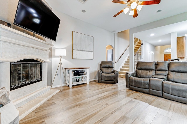 2011 Wembley Way, Rosenberg, TX 77471 - living area featuring a fireplace, light wood finished floors, a ceiling fan, and stairs