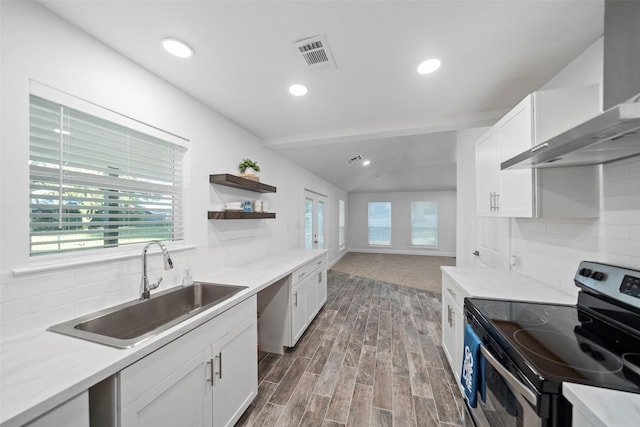 kitchen featuring backsplash, visible vents, wall chimney exhaust hood, electric stove, and a sink