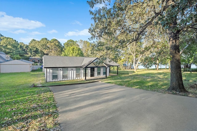 single story home with a shingled roof and a front lawn
