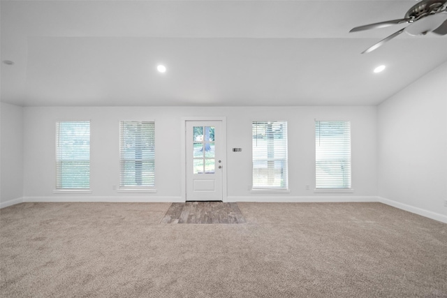unfurnished living room featuring a ceiling fan, carpet flooring, plenty of natural light, and lofted ceiling