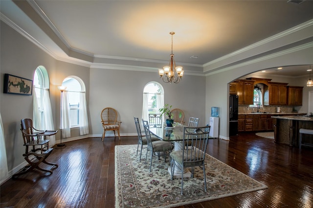 dining space with dark wood-style flooring, baseboards, an inviting chandelier, crown molding, and arched walkways