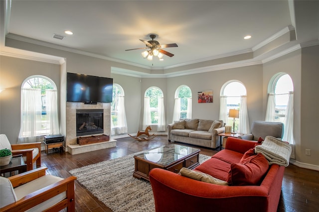 living room featuring a healthy amount of sunlight, a high end fireplace, dark wood-style flooring, and ceiling fan