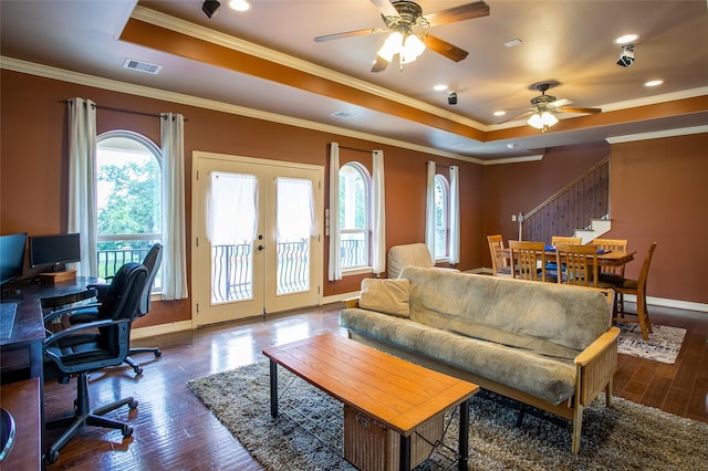 living room with ceiling fan, visible vents, stairway, dark wood-style flooring, and a raised ceiling