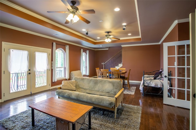 living area with ceiling fan, stairs, a raised ceiling, french doors, and wood-type flooring