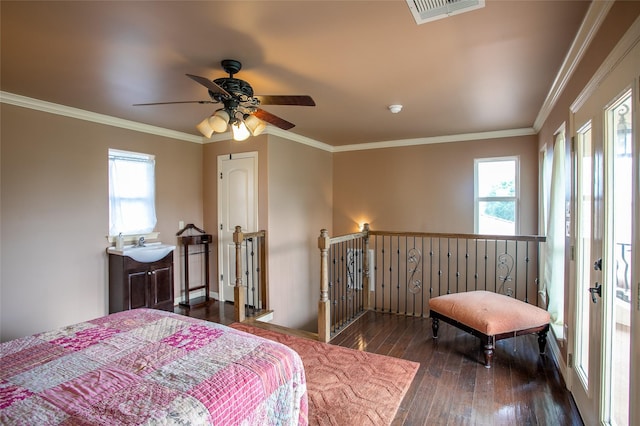bedroom with crown molding, visible vents, multiple windows, and hardwood / wood-style floors