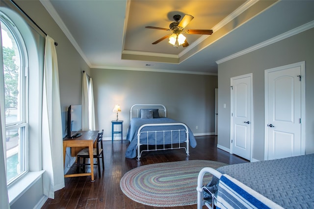 bedroom with crown molding, a ceiling fan, a raised ceiling, baseboards, and hardwood / wood-style flooring