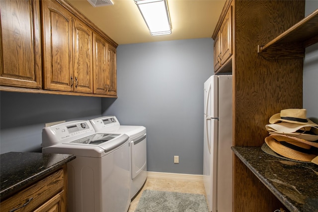 laundry room featuring baseboards, light tile patterned floors, visible vents, cabinet space, and washer and dryer