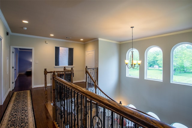 corridor with an inviting chandelier, dark wood finished floors, visible vents, recessed lighting, and an upstairs landing