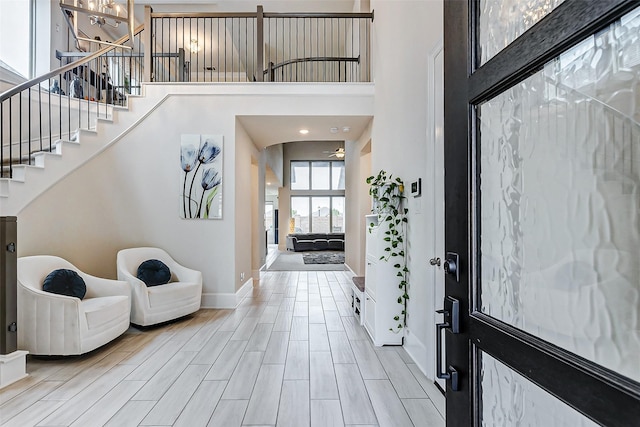 21123 Coral View Dr, Cypress, TX 77433 - foyer with light wood-style flooring, baseboards, a towering ceiling, and stairs