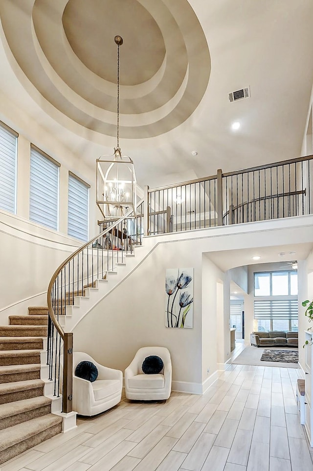 21123 Coral View Dr, Cypress, TX 77433 - staircase with visible vents, a chandelier, a high ceiling, wood finished floors, and baseboards