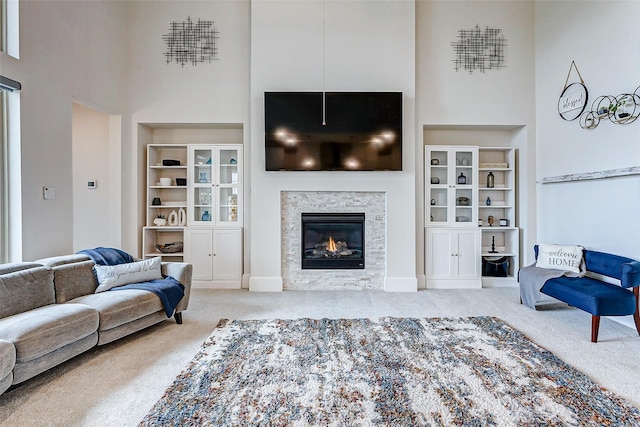 21123 Coral View Dr, Cypress, TX 77433 - carpeted living area featuring built in shelves, a glass covered fireplace, and a towering ceiling