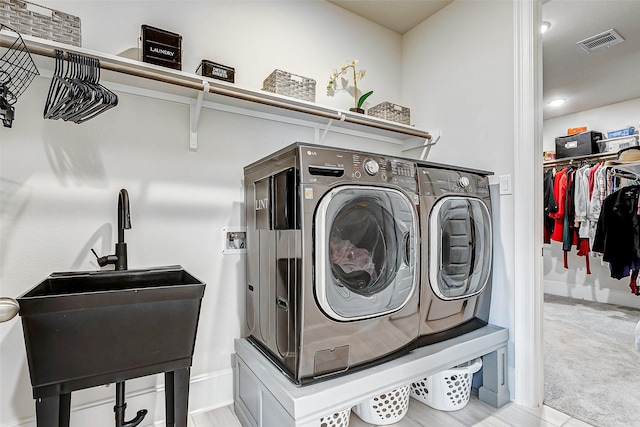 21123 Coral View Dr, Cypress, TX 77433 - washroom with baseboards, washing machine and clothes dryer, visible vents, laundry area, and a sink
