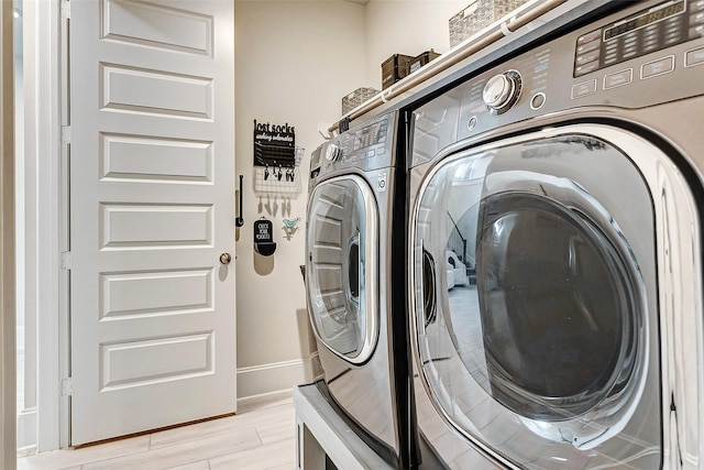 21123 Coral View Dr, Cypress, TX 77433 - laundry area featuring washer and clothes dryer, light wood-type flooring, laundry area, and baseboards
