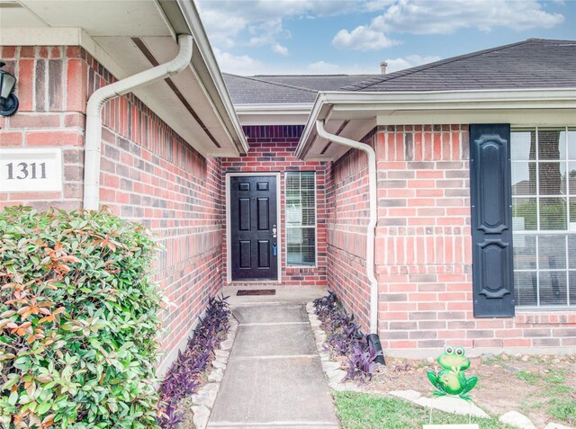 1311 Holly Lake Ct, Katy, TX 77450 - view of exterior entry with brick siding and a shingled roof