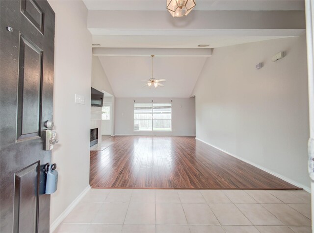 1311 Holly Lake Ct, Katy, TX 77450 - tiled entryway with a fireplace, vaulted ceiling with beams, baseboards, and a ceiling fan