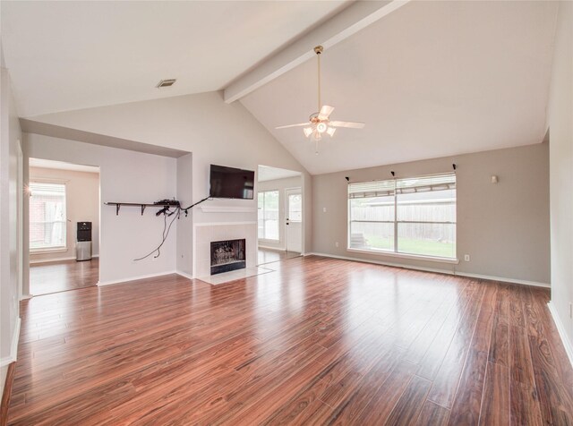 1311 Holly Lake Ct, Katy, TX 77450 - unfurnished living room with a ceiling fan, wood finished floors, a tile fireplace, beamed ceiling, and baseboards