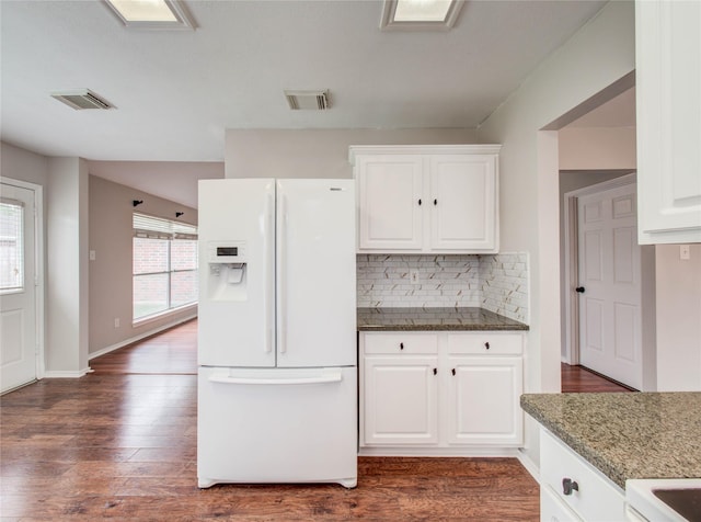 1311 Holly Lake Ct, Katy, TX 77450 - kitchen featuring white cabinets, visible vents, white refrigerator with ice dispenser, and decorative backsplash