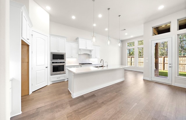 8215 Mount Washburn Ln, Porter, TX 77365 - kitchen with a sink, light countertops, light wood-style floors, white cabinetry, and stainless steel appliances