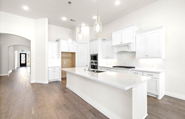 8215 Mount Washburn Ln, Porter, TX 77365 - kitchen featuring custom range hood, a spacious island, decorative backsplash, stainless steel appliances, and a sink