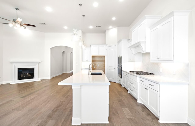 8215 Mount Washburn Ln, Porter, TX 77365 - kitchen featuring ceiling fan, arched walkways, appliances with stainless steel finishes, a sink, and open floor plan