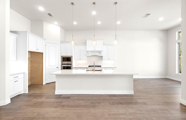 8215 Mount Washburn Ln, Porter, TX 77365 - kitchen featuring a kitchen island with sink, built in microwave, visible vents, oven, and a sink