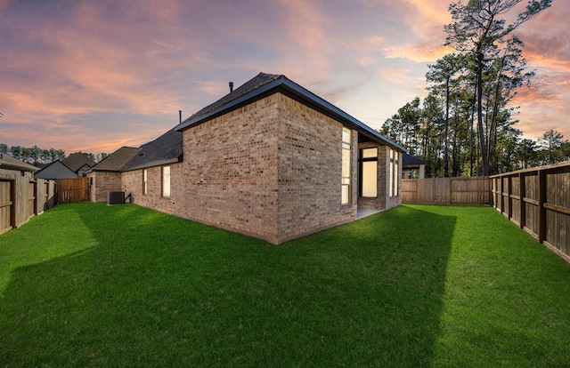 8215 Mount Washburn Ln, Porter, TX 77365 - rear view of house with a yard, a fenced backyard, central AC unit, and brick siding