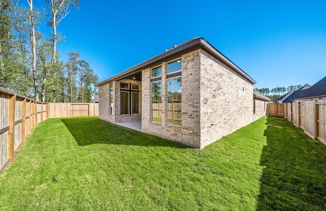 8215 Mount Washburn Ln, Porter, TX 77365 - rear view of house featuring brick siding, a fenced backyard, and a lawn