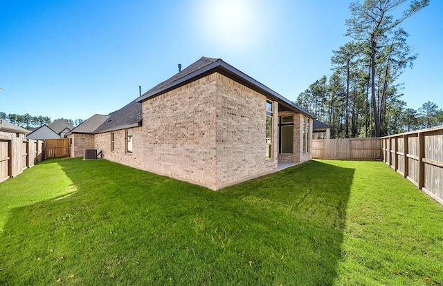 8215 Mount Washburn Ln, Porter, TX 77365 - back of house featuring a yard, a fenced backyard, brick siding, and cooling unit