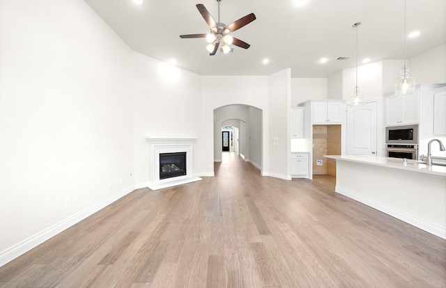 8215 Mount Washburn Ln, Porter, TX 77365 - unfurnished living room with visible vents, arched walkways, a ceiling fan, recessed lighting, and light wood finished floors