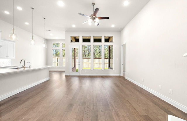 8215 Mount Washburn Ln, Porter, TX 77365 - unfurnished living room with baseboards, recessed lighting, a ceiling fan, dark wood-type flooring, and a sink