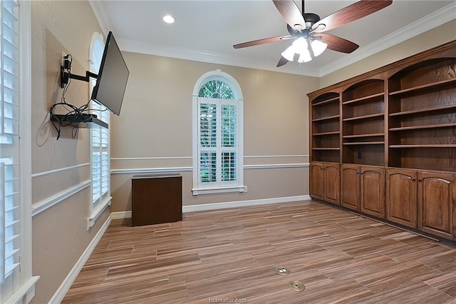 unfurnished office with crown molding, ceiling fan, light wood-type flooring, and baseboards