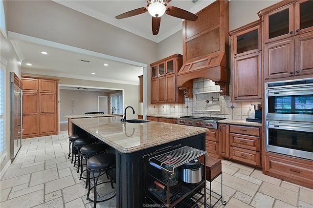 kitchen featuring stone tile floors, ornamental molding, recessed lighting, a sink, and decorative backsplash