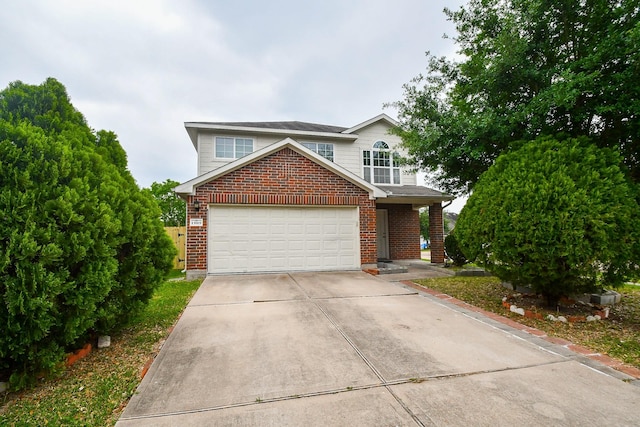 traditional-style home featuring a garage, brick siding, and driveway
