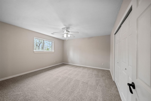unfurnished bedroom with a closet, a ceiling fan, visible vents, carpet flooring, and baseboards
