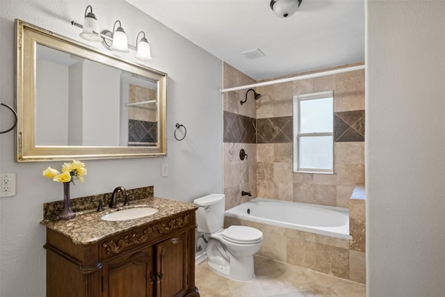bathroom featuring tile patterned floors, toilet, vanity, and tiled shower / bath