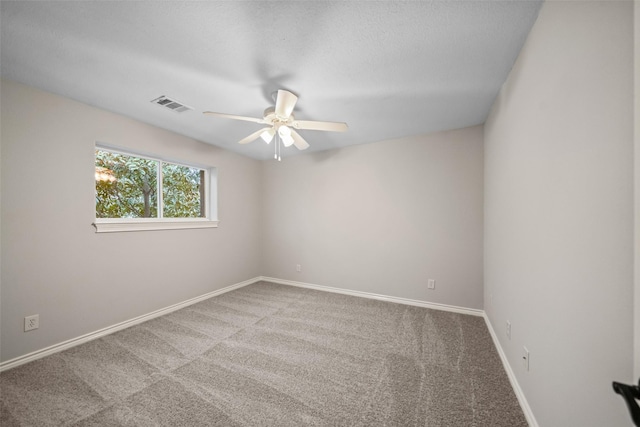 carpeted empty room with visible vents, ceiling fan, and baseboards
