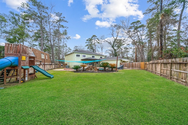 view of yard with a fenced backyard and a playground