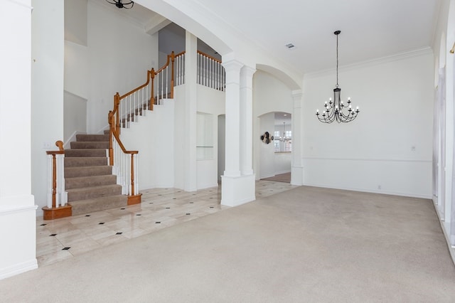 interior space featuring an inviting chandelier, decorative columns, ornamental molding, and carpet