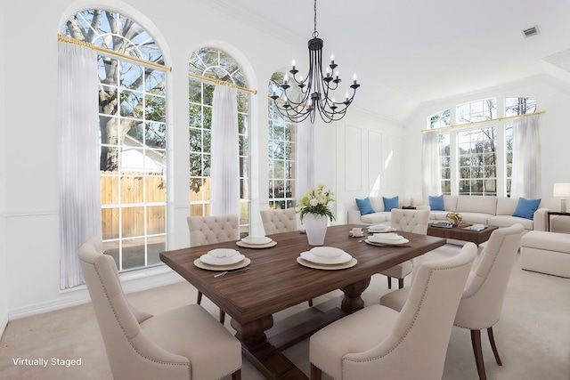 dining space with a chandelier, vaulted ceiling, and visible vents