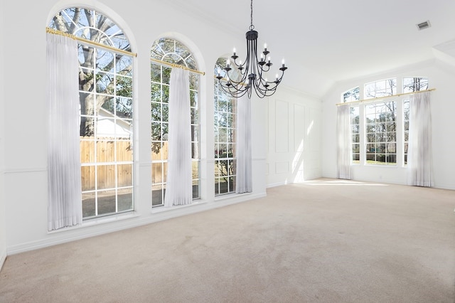 unfurnished dining area with carpet, visible vents, an inviting chandelier, and lofted ceiling