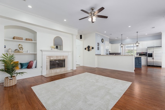 living room with crown molding, ceiling fan, recessed lighting, and a fireplace
