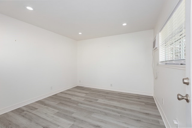 empty room with light wood-type flooring, recessed lighting, and baseboards