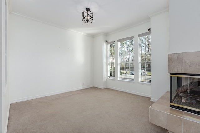 unfurnished living room with crown molding, baseboards, a tiled fireplace, and carpet
