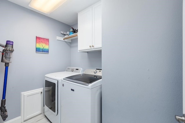 clothes washing area with cabinet space and independent washer and dryer