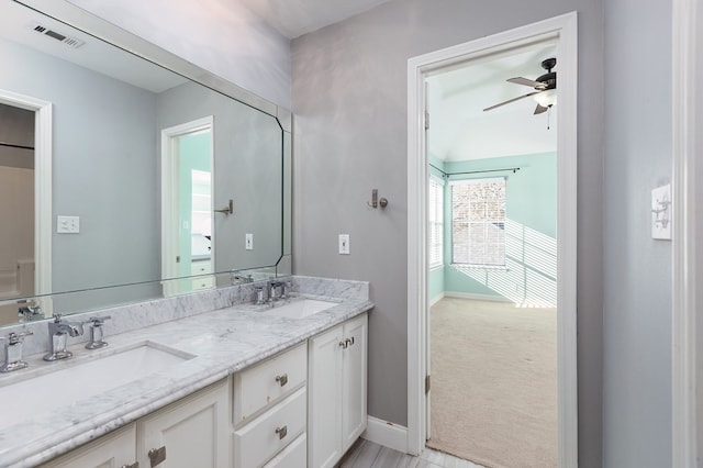 full bathroom with a sink, baseboards, a ceiling fan, and double vanity