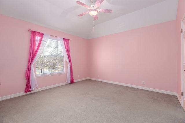 unfurnished room with carpet, baseboards, vaulted ceiling, and ceiling fan