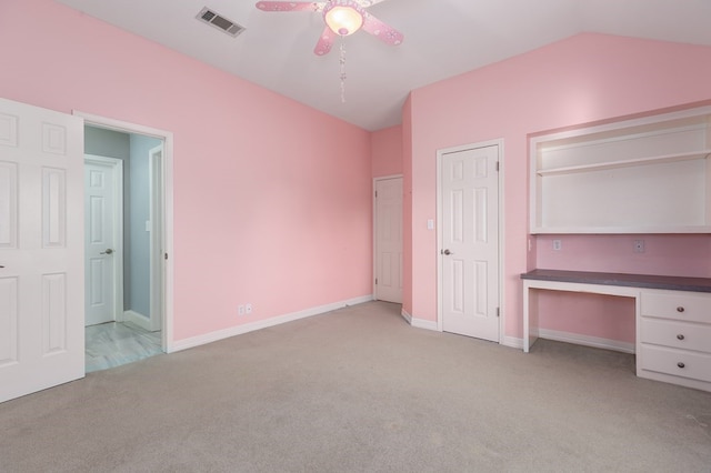 unfurnished bedroom featuring carpet, visible vents, baseboards, and vaulted ceiling