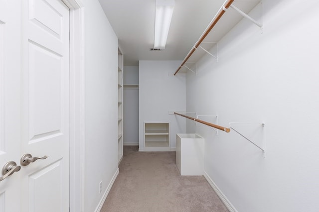 spacious closet featuring visible vents and light colored carpet